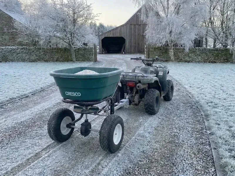 Green Cresco tow spreader hitched to a quad bike on a frosty farm track